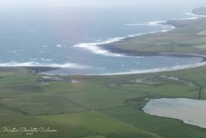 Utsikt over Bay of Skaill med Skara Brae i forgrunnen.